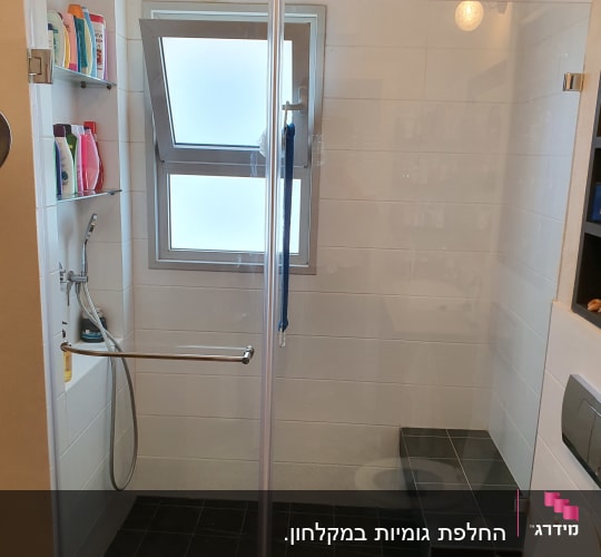מקלחת עם ראש גשם, מדפים עם מוצרי רחצה